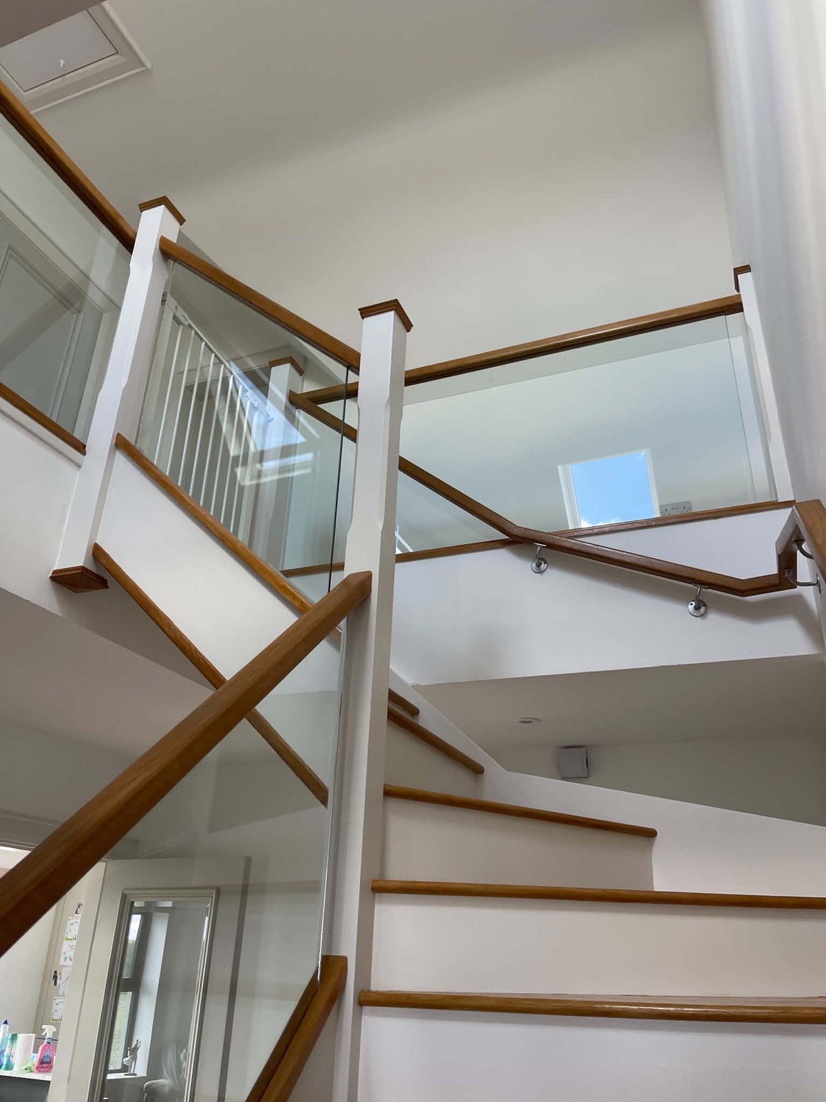Clean staircase with timber handrails and clear glass balustrades